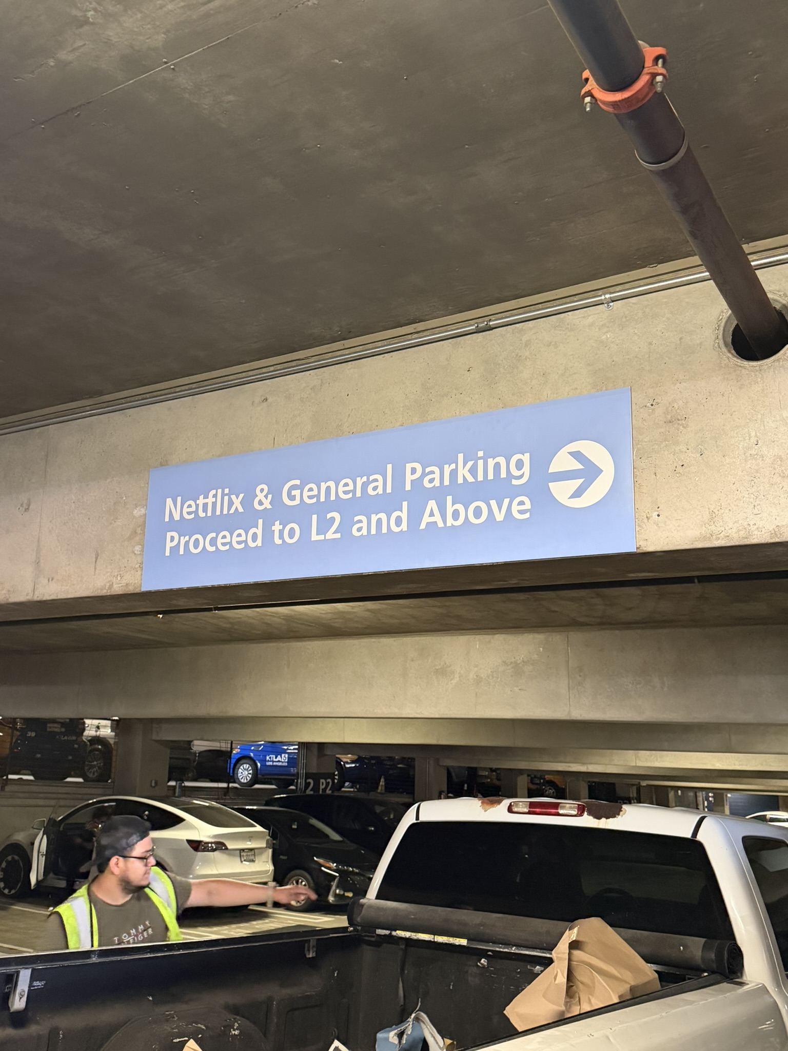 Blue parking garage sign directing Netflix and general parking traffic toward level L2 and above with a right arrow