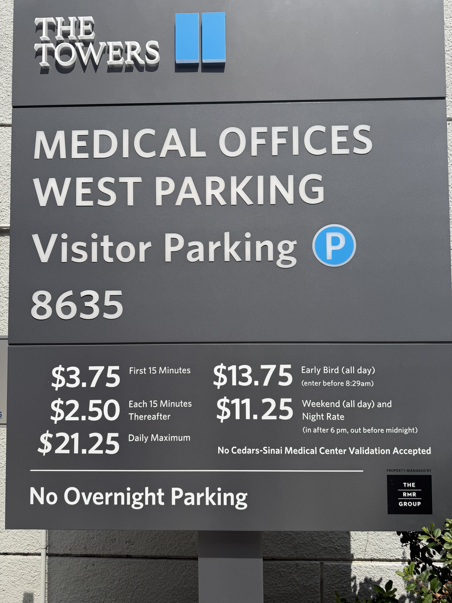 Parking rate panel updated with white vinyl pricing information on an existing gray sign